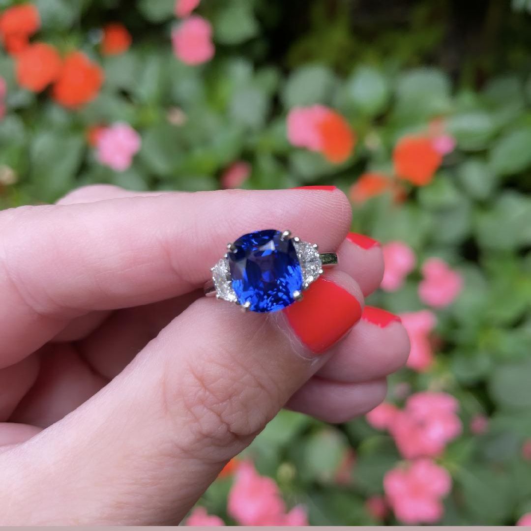 Bayco Jewels Madagascar Sapphire and Diamond Ring. ﻿A platinum ring centering a 5.11 carat cushion-shaped Madagascar sapphire flanked by two half moon diamonds (0.67ctw). Finger size 5 (resize possible).