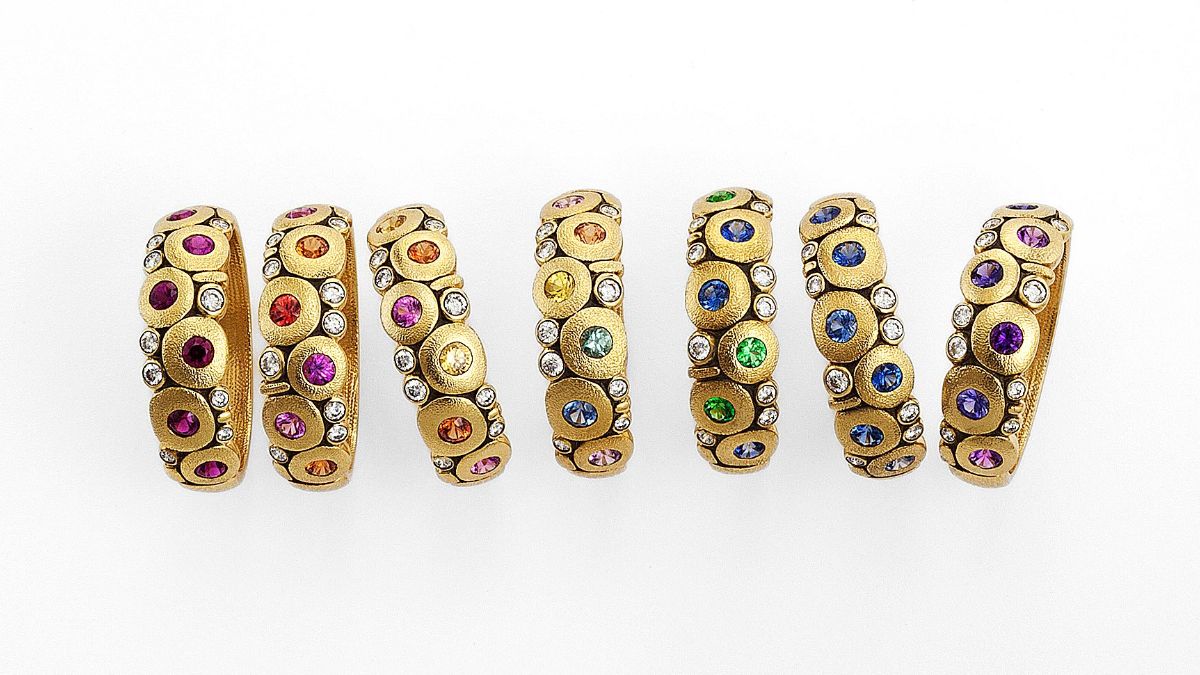 18k yellow gold diamond and gemstone artistic rings on a white background