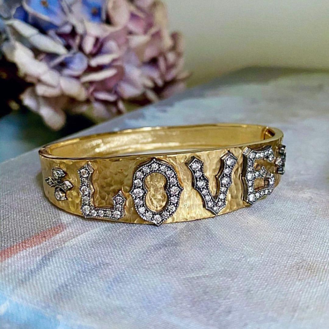 yellow gold wide bracelet with the word "Love" written in silver and diamonds