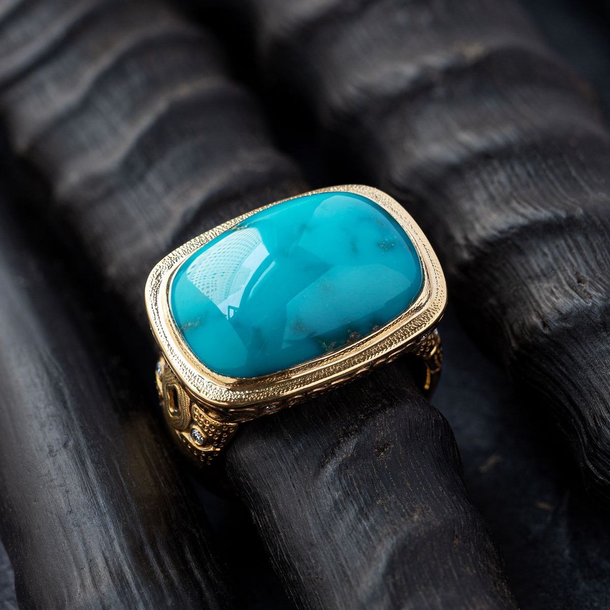 Blue gemstone rectangular gold ring on a black background
