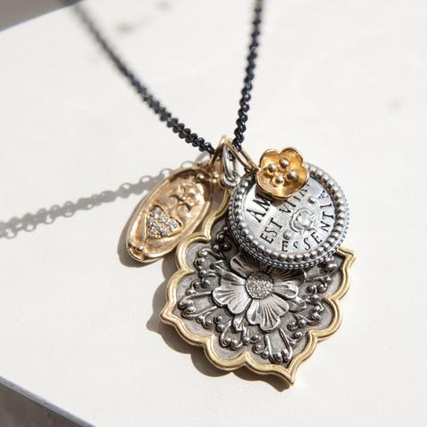 4 charms in silver and yellow gold on a chain