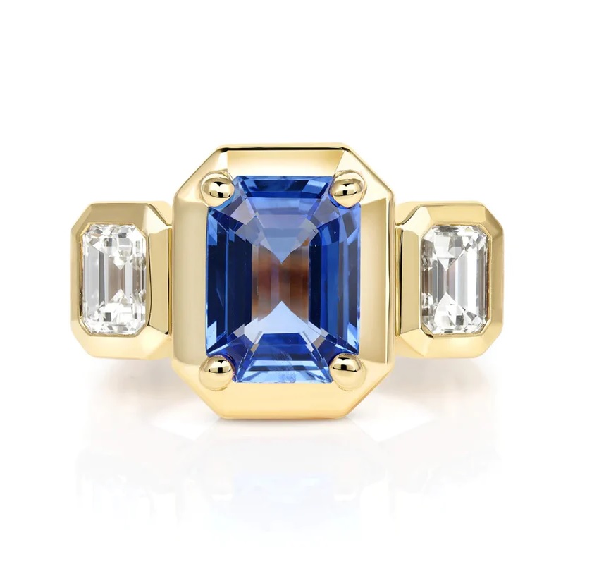 emerald cut blue sapphire ring with two emerald cut diamonds on white back ground