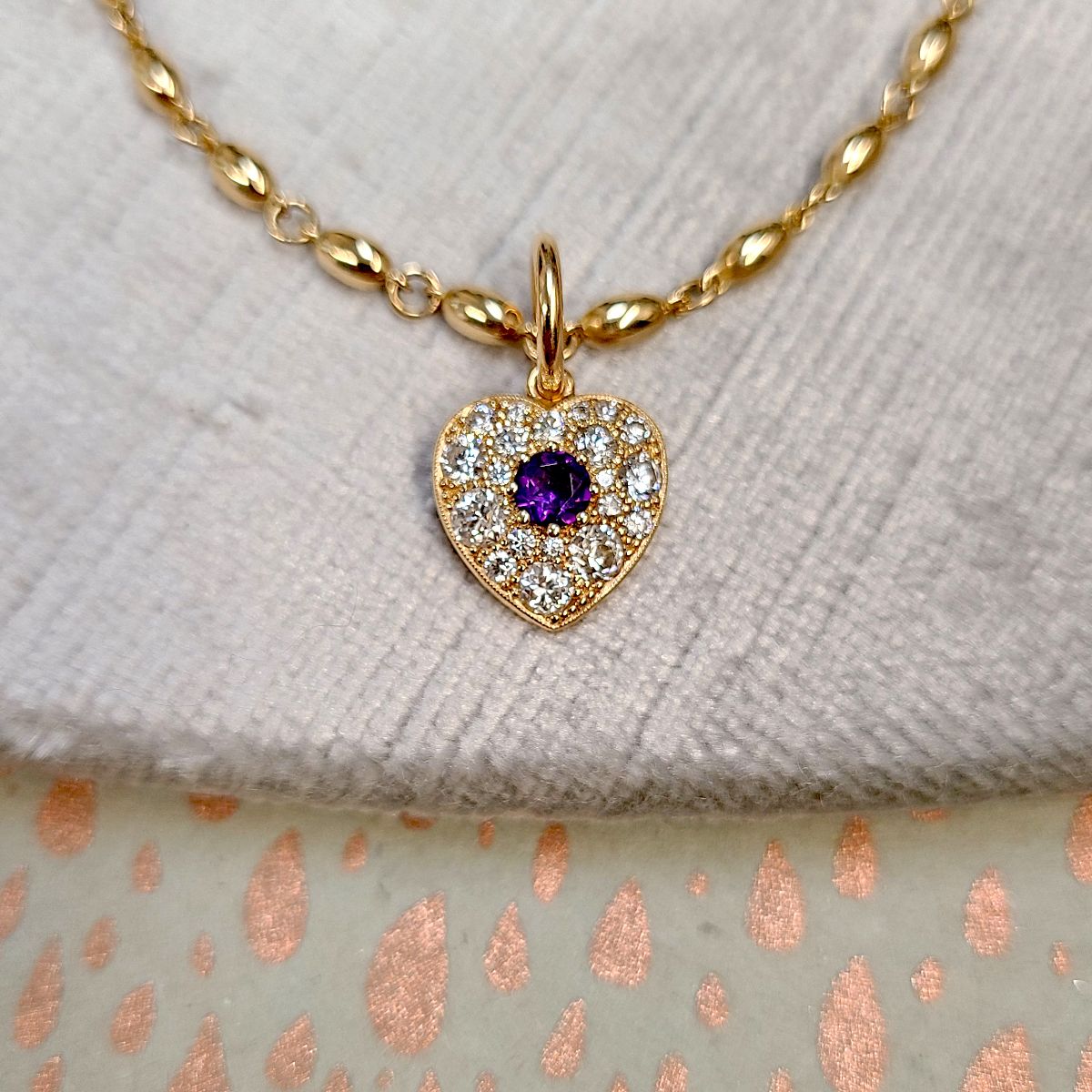 yellow gold heart necklace with diamonds paved into it on a gold chain