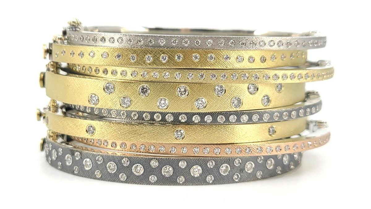 Stack of diamond bangle bracelets in yellow gold and silver