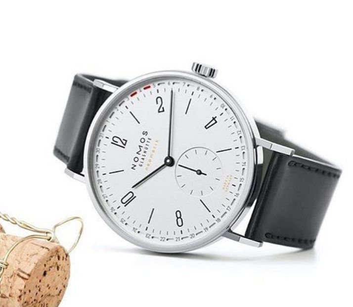 white dial watch with champagne cork on white background