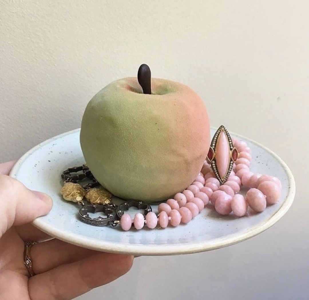 Plate with apple shaped pastry and pink opal necklace and earrings