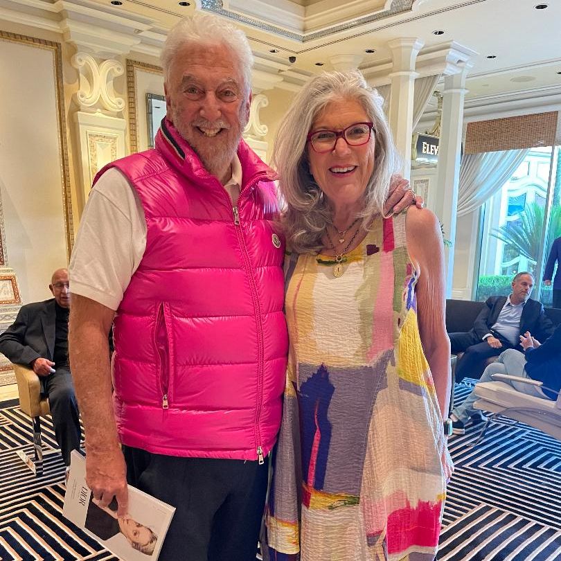 man and woman standing and smiling at an event