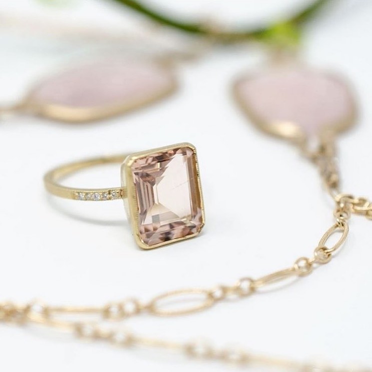 Jennifer Dawes morganite pink ring in rose gold with necklace draped around it.