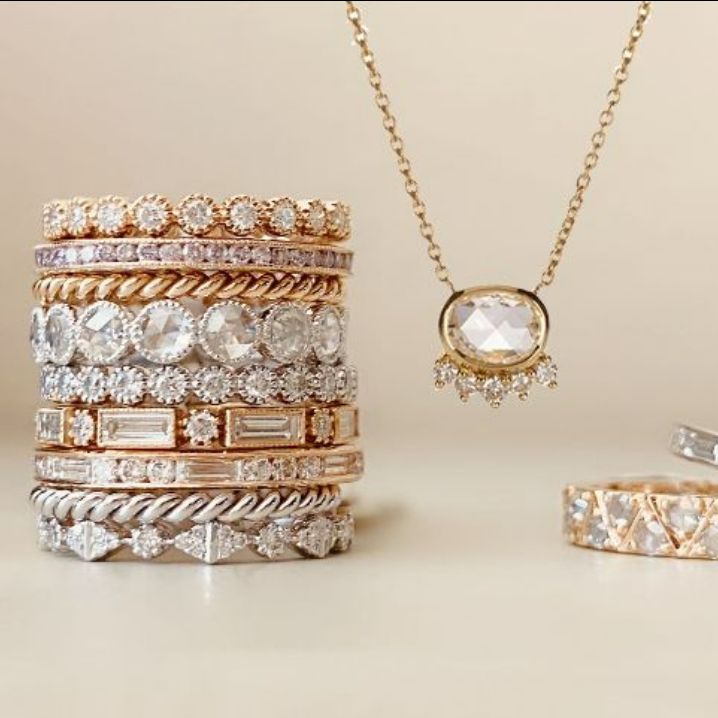 Stack of rose gold, white gold and yellow gold rings with pendant hanging down