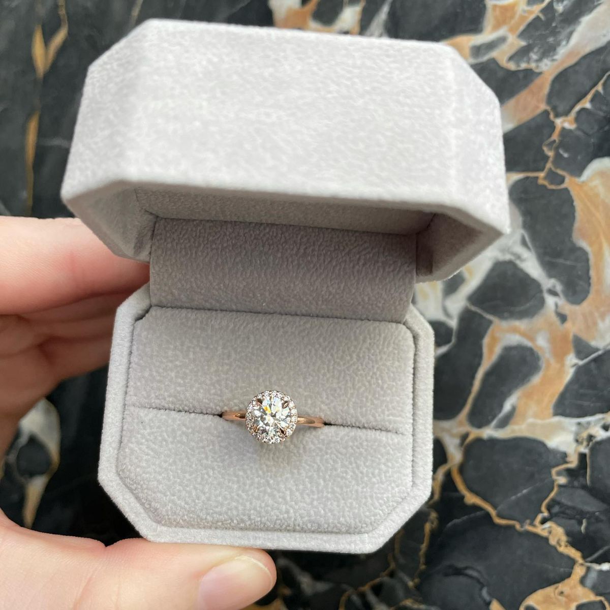 Link takes you to designer engagement rings. Photo shows ring box with round diamond engagement ring inside