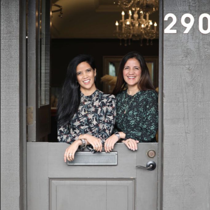 Photo of sisters, Prena and Pratima, behind a dutch door with the top open