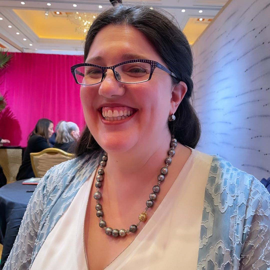 Woman wearing glasses wearing a pearl and diamond necklace
