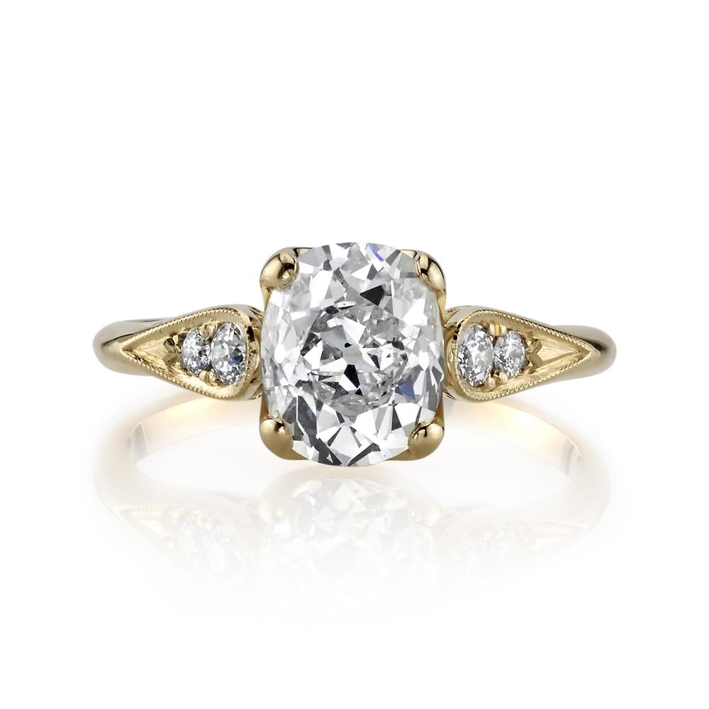yellow gold large cushion diamond ring with two small round side diamonds