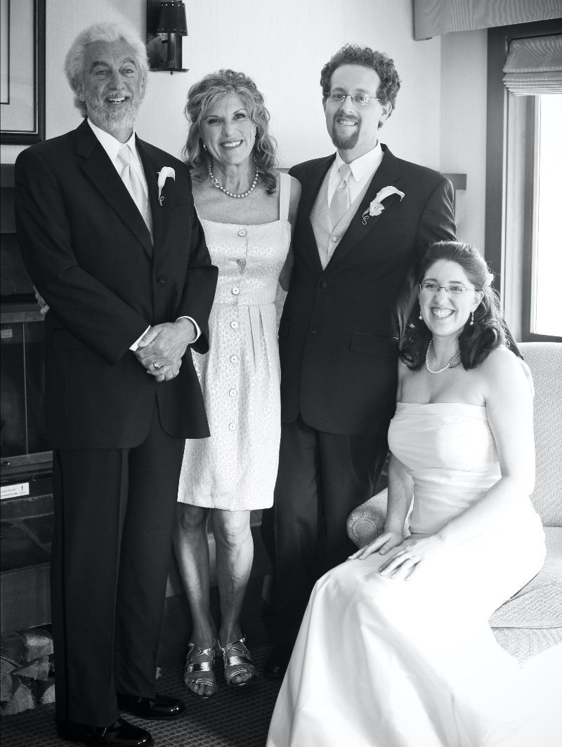 Black and white photo of two men and two women dressed up for a wedding