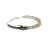 side angle of Rene Escobar 18k yellow gold "chloe" diamond bangle bracelet with diamonds on front and a sterling silver back