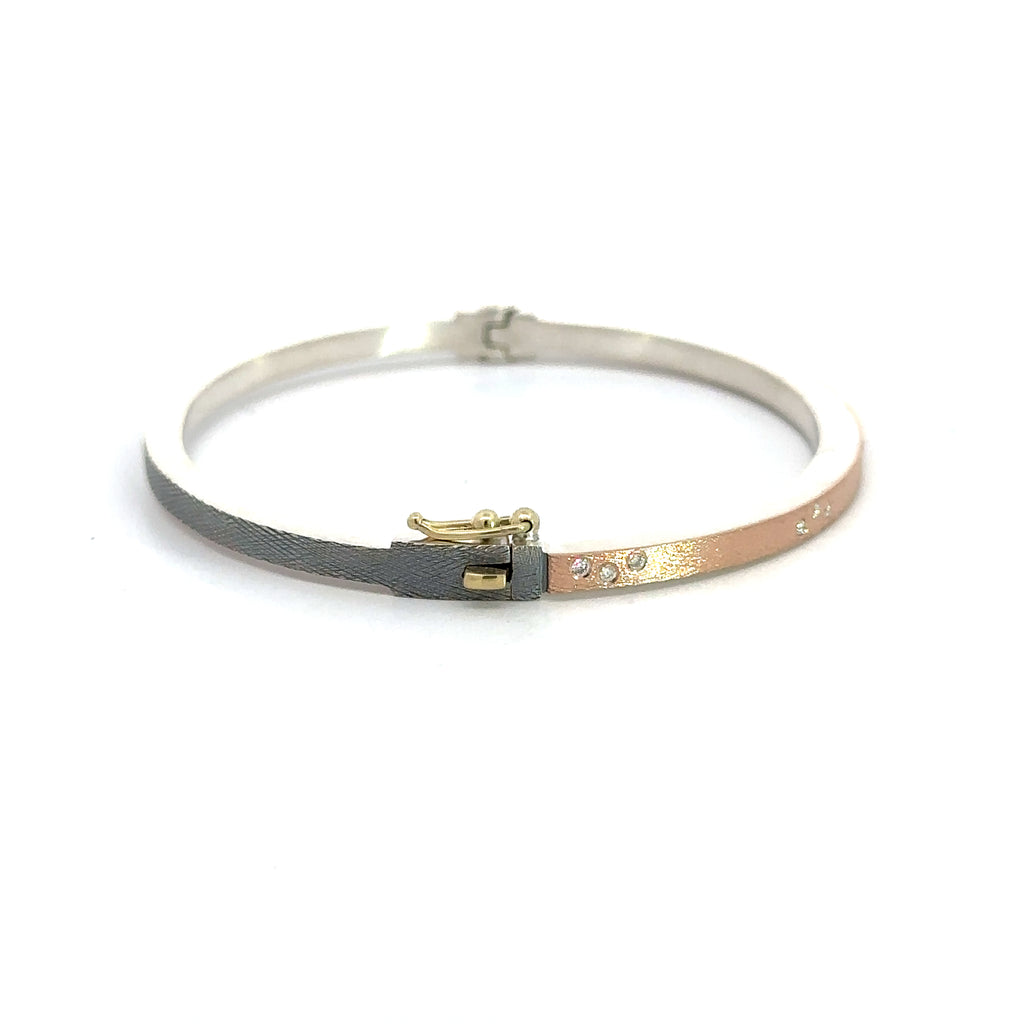 side angle of Rene Escobar 18k rose gold "maru" diamond bangle bracelet with diamonds on front in groups of 3 and a silver backside