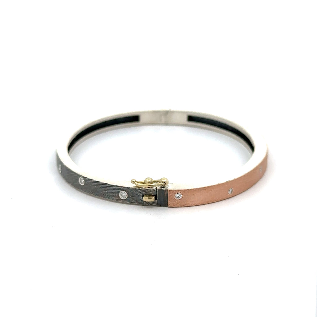 side angle of Rene Escobar 18K rose gold "carol" bangle bracelets with diamonds throughout and a silver backside