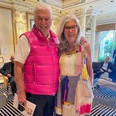 Man with pink vest and woman with color blocking dress at event