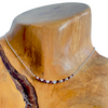 18k white gold ruby and diamond necklace pictured on a wooden neck