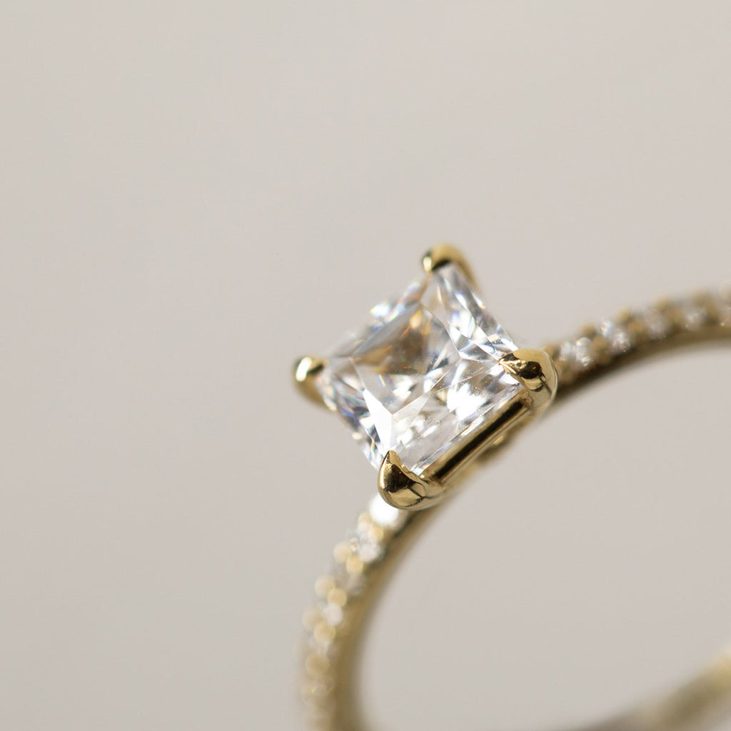Princess cut diamond ring closeup with pave diamonds on rim