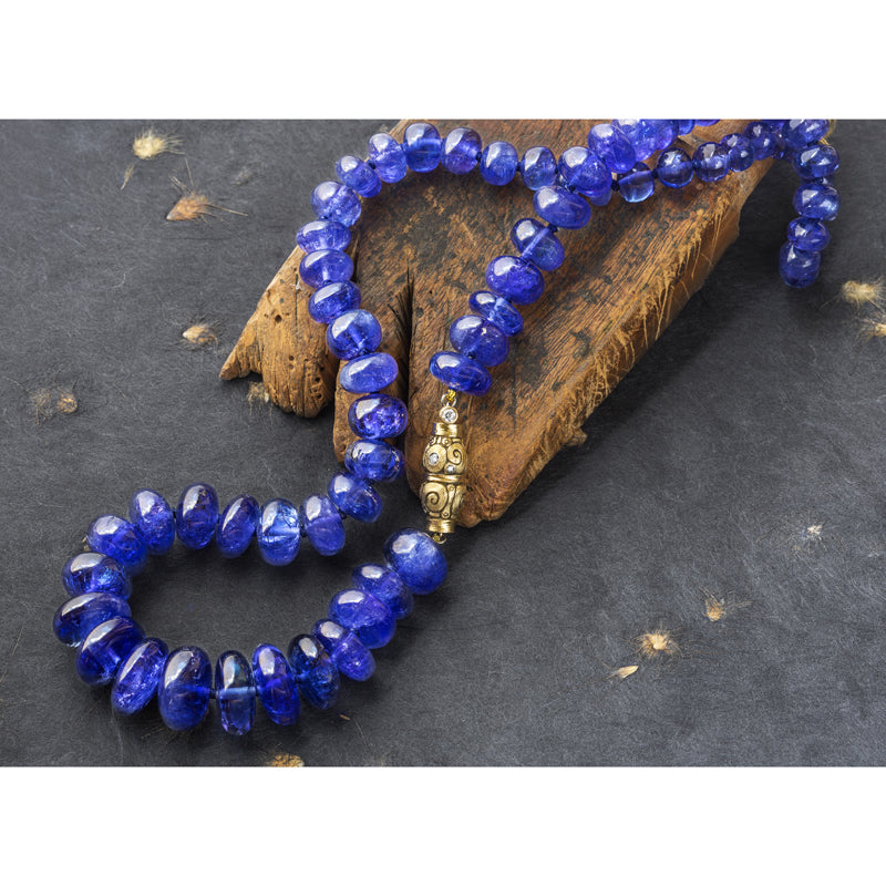 Tanzanite bead necklace with 18K yellow gold and diamond "Seashell" clasp, grey background