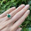 Bayco Jewels platinum ring centering a round 2.42 carat Zambian emerald flanked by round brilliant cut colorless diamonds on hand