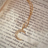 18K yellow gold "Crescent" rose cut diamond pendant with paper clip chain laying on top of newspaper