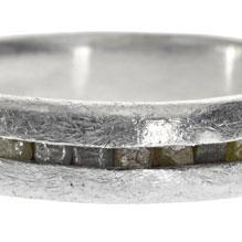 Closeup photo of a palladium ring with channel set raw diamond cubes by Todd Reed