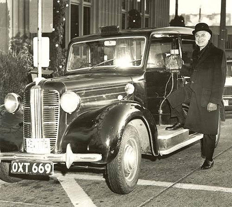 Black and white photo of Sid Thal with his London Taxi cab.