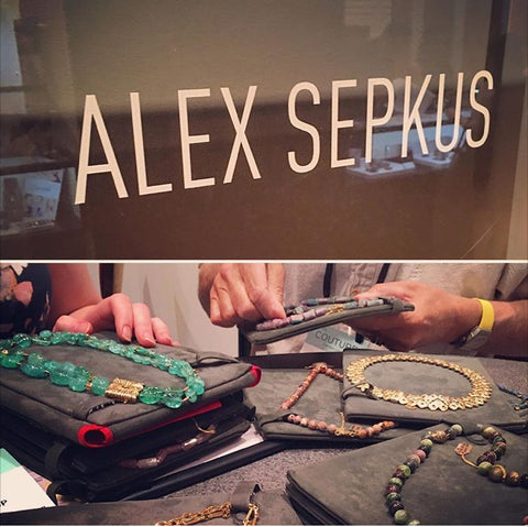 Alex Sepkus sign and necklaces splayed over table.