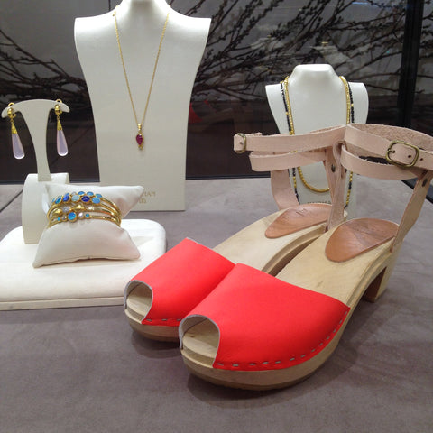 Red bryers clogs with jewelry behind.