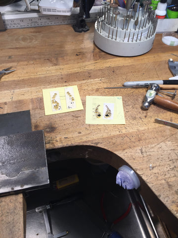 Close up of jeweler bench at todd reed with sketches of earrings on top