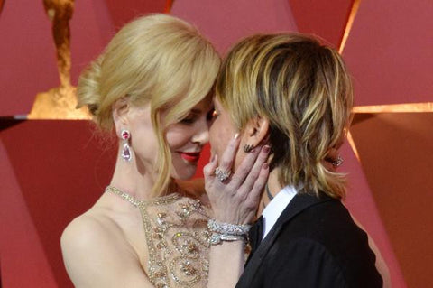 Photo of NIcole Kidman holding her husband's head on the red carpet.