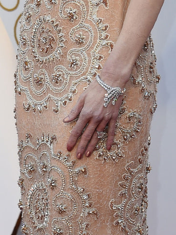 photo of actress in peach colored dress with bracelet and large diamond ring on her hand