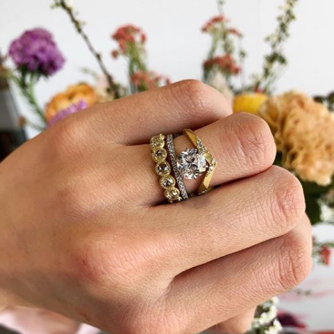 woman wearing Samantha Louise star tracer ring with other diamond rings on finger, elegant diamond rings