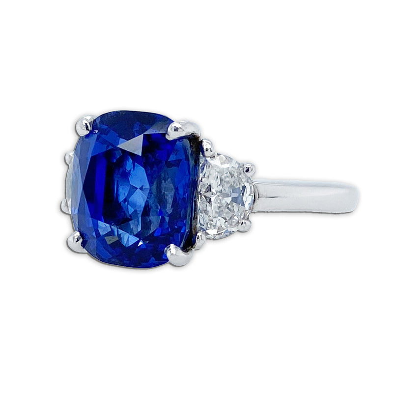 Side view of Bayco Jewels platinum ring centering a 5.11 carat cushion-shaped Madagascar sapphire flanked by two half moon diamonds