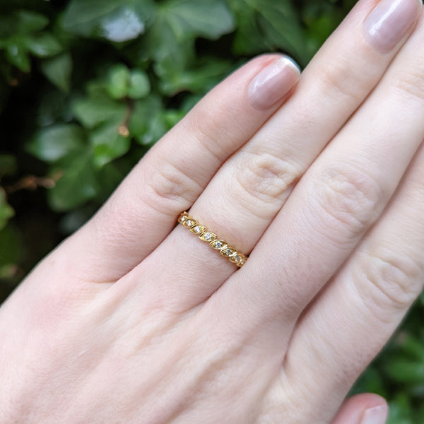 18K yellow gold diamond eternity ring with leaf shapes on hand